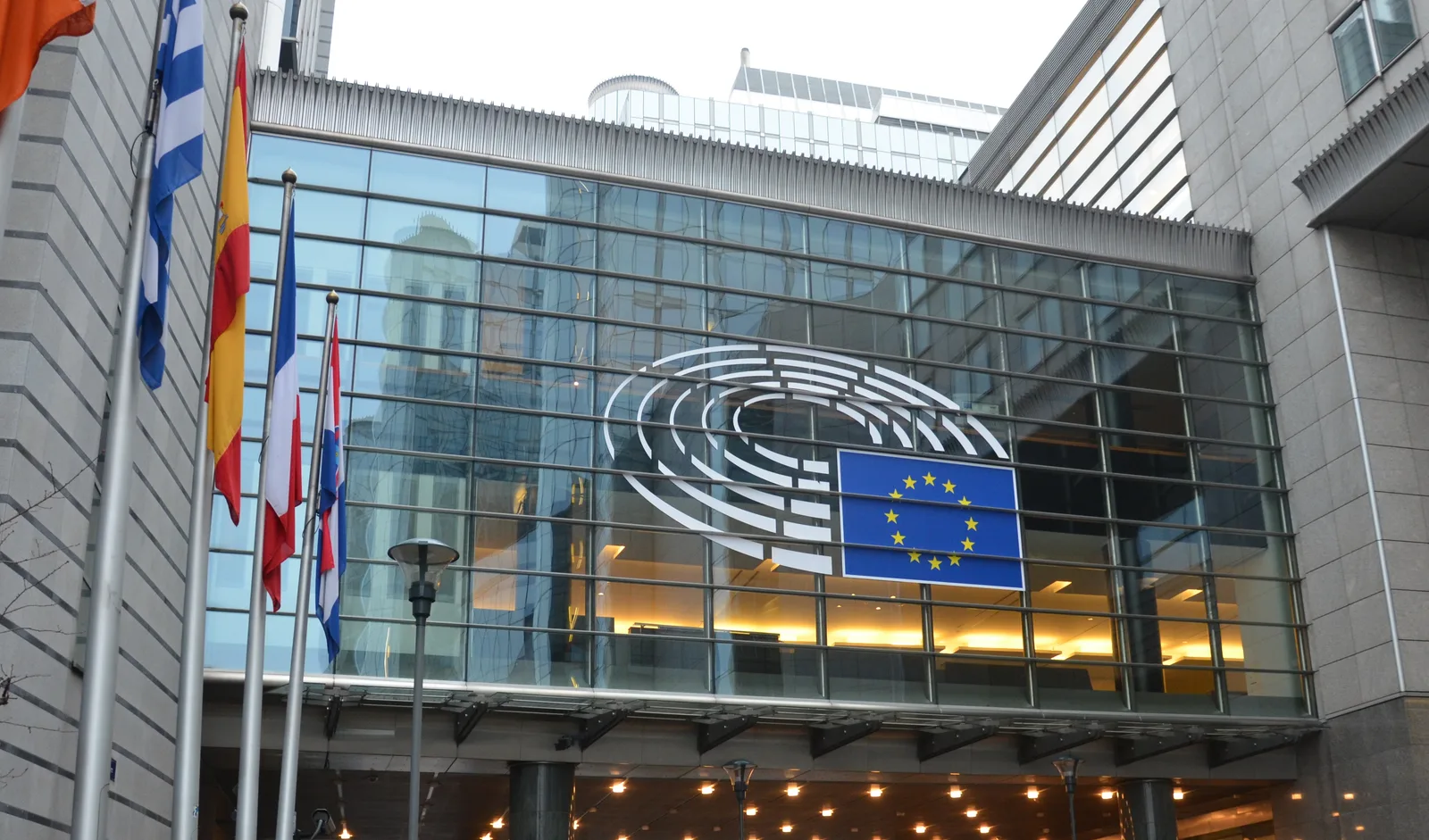 벨기에 브뤼셀에 위치한 유럽의회(European Parliament) 건물 외관 사진, EU기와 유럽의회 로고가 보인다